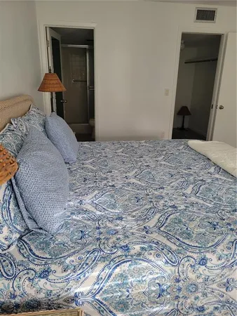 a large bed sitting in a bedroom next to a window