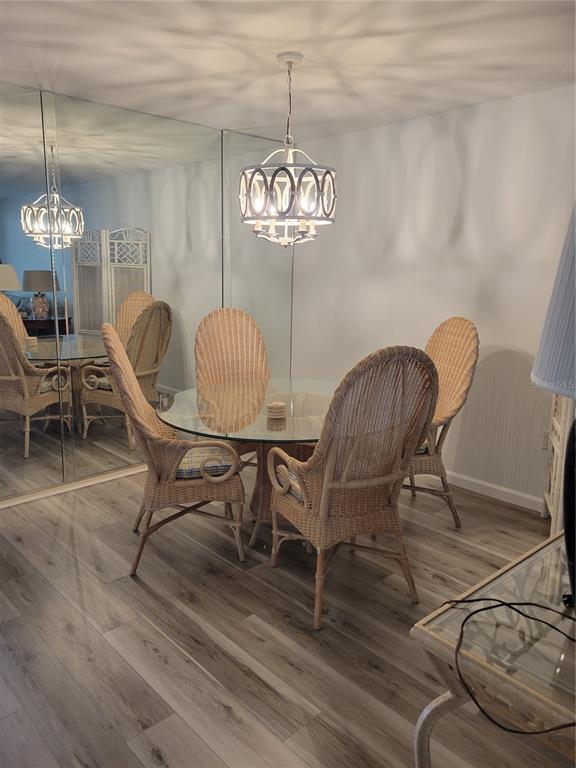 220 Santa Maria Street, Unit 442 Venice, FL 34285 - Photo 8 of 27 a dining room with furniture a chandelier and wooden floor