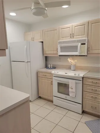 a view of kitchen with granite countertop cabinets sink and window
