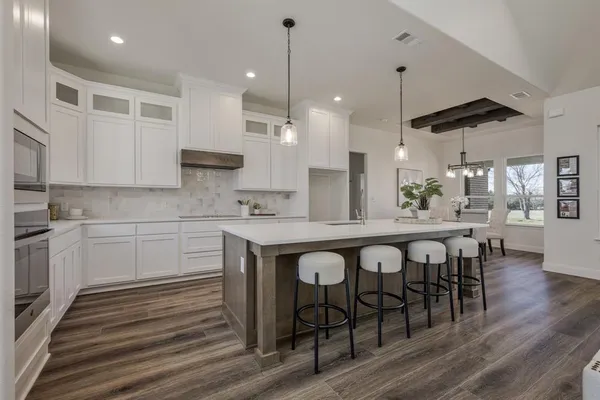 a large kitchen with a table and chairs