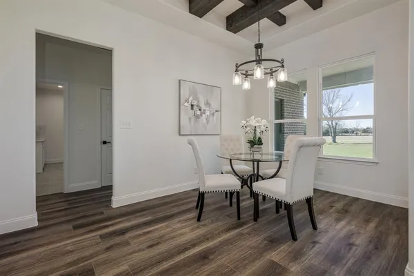 a dining room with wooden floor a chandelier a wooden table and chairs