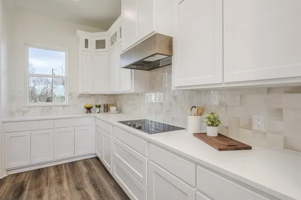 a kitchen with white cabinets a sink and dishwasher