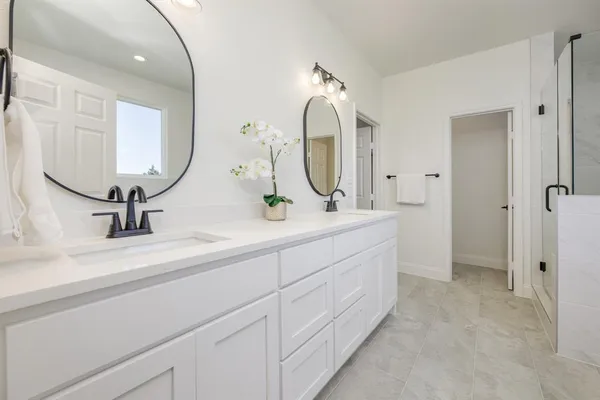 a bathroom with a double vanity sink and a mirror