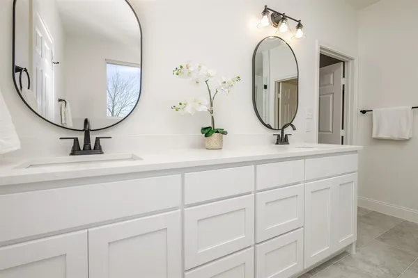 a bathroom with double vanity sinks and a mirror