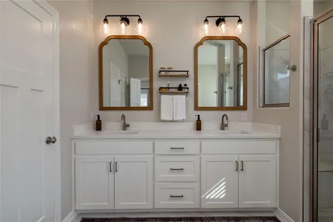 a bathroom with double vanity sink and a mirror