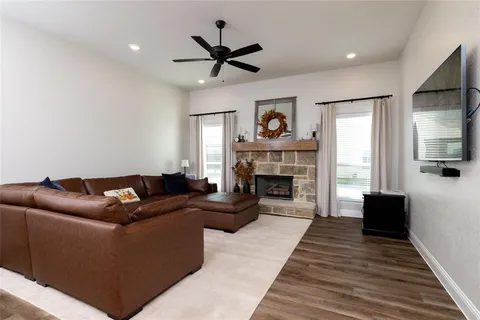 a living room with furniture a large window and a fireplace