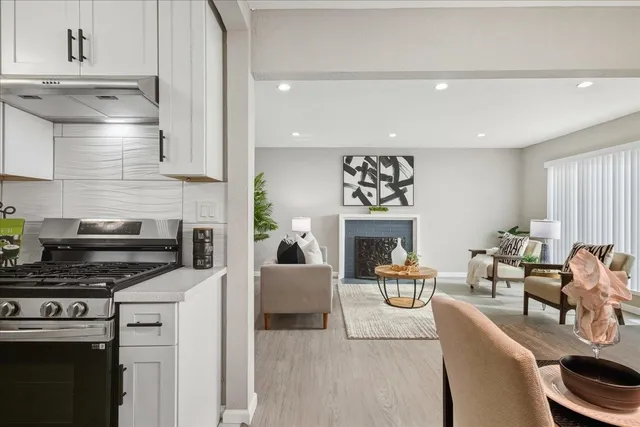 a living room with furniture a fireplace and a kitchen view
