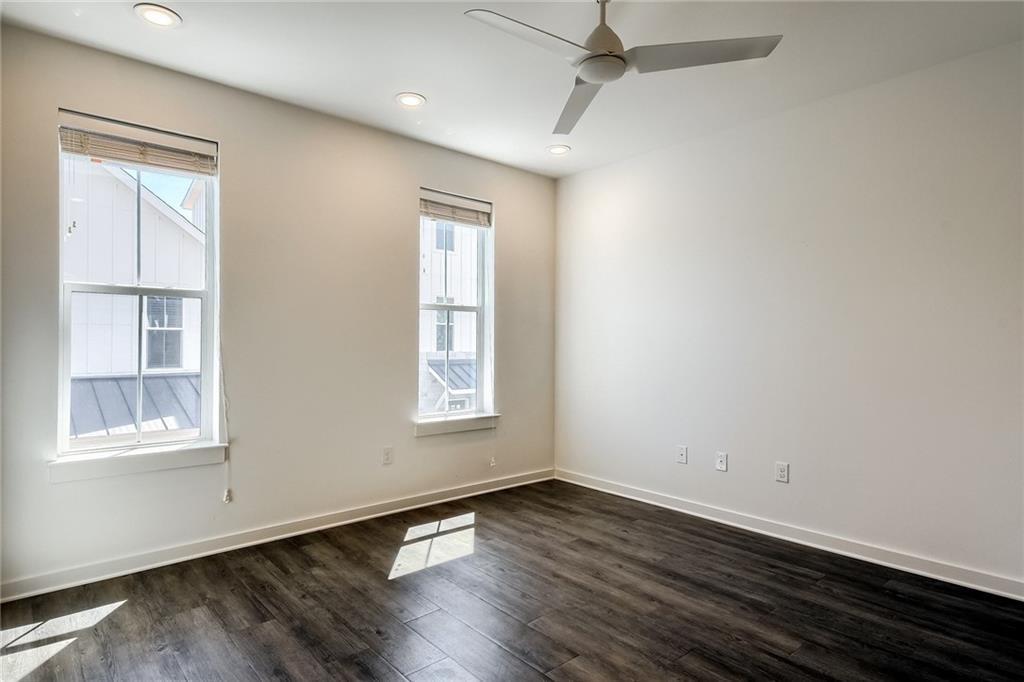 2624 Metcalfe Road, Unit 7 Austin, TX 78741 - Photo 11 of 31 Spacious room featuring wood-finish flooring, two large windows with blinds, a ceiling fan, and recessed lighting