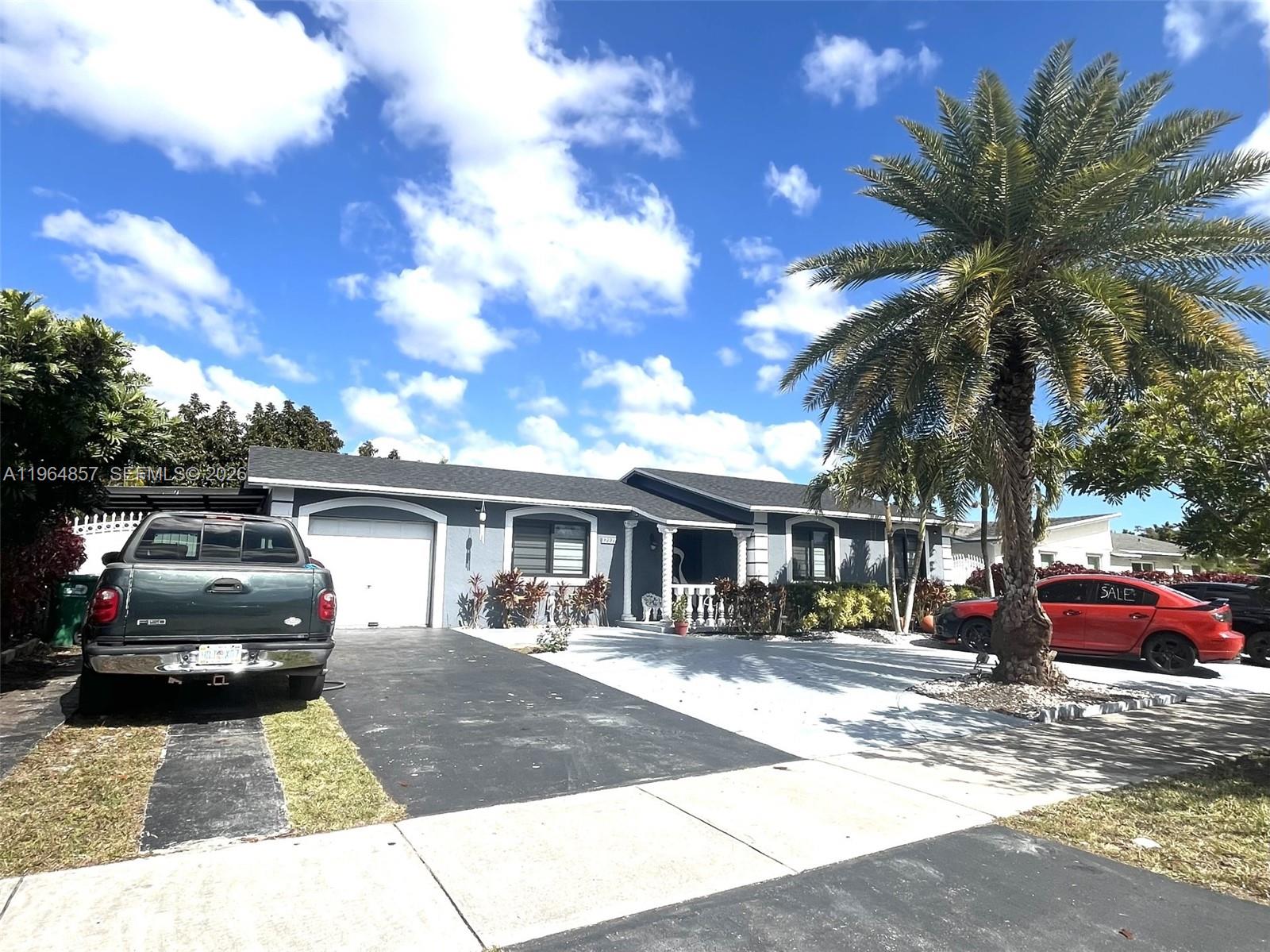 12271 Southwest 187th Street Miami, FL 33177 - Photo 1 of 27 a front view of a house with a garden and plants