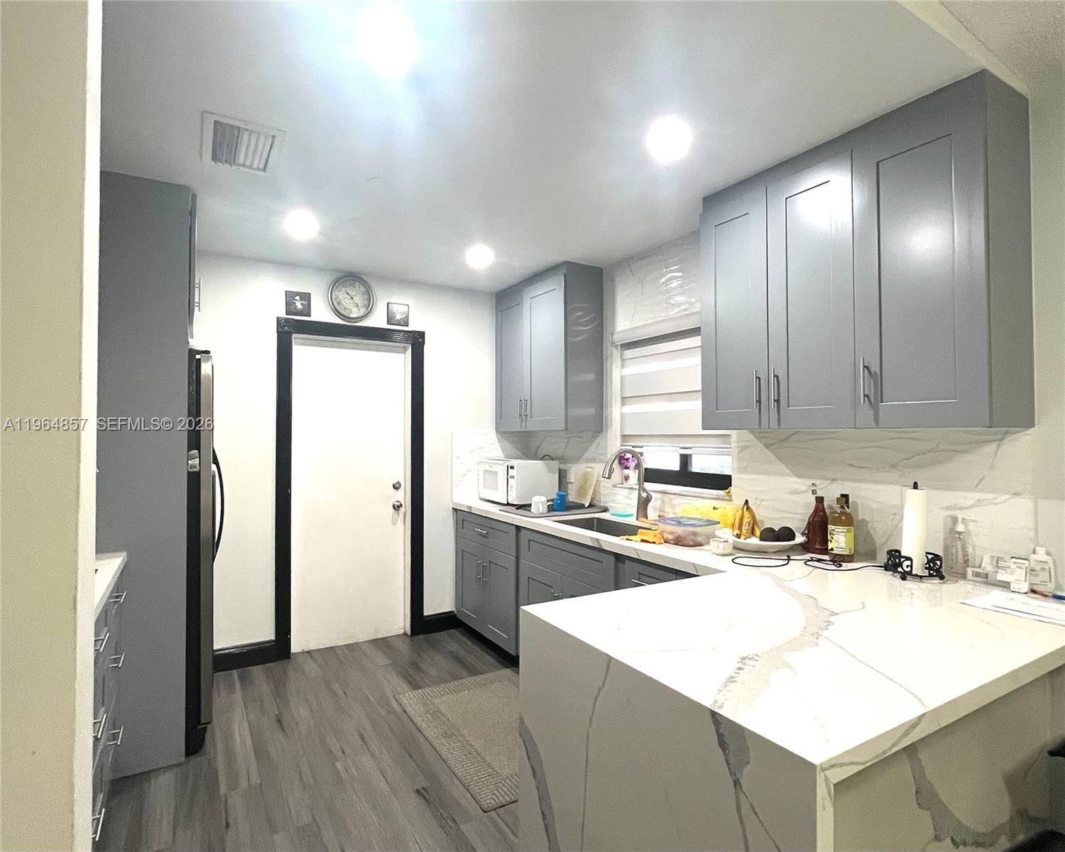 12271 Southwest 187th Street Miami, FL 33177 - Photo 8 of 27 a kitchen with a refrigerator a sink and dishwasher with wooden floor