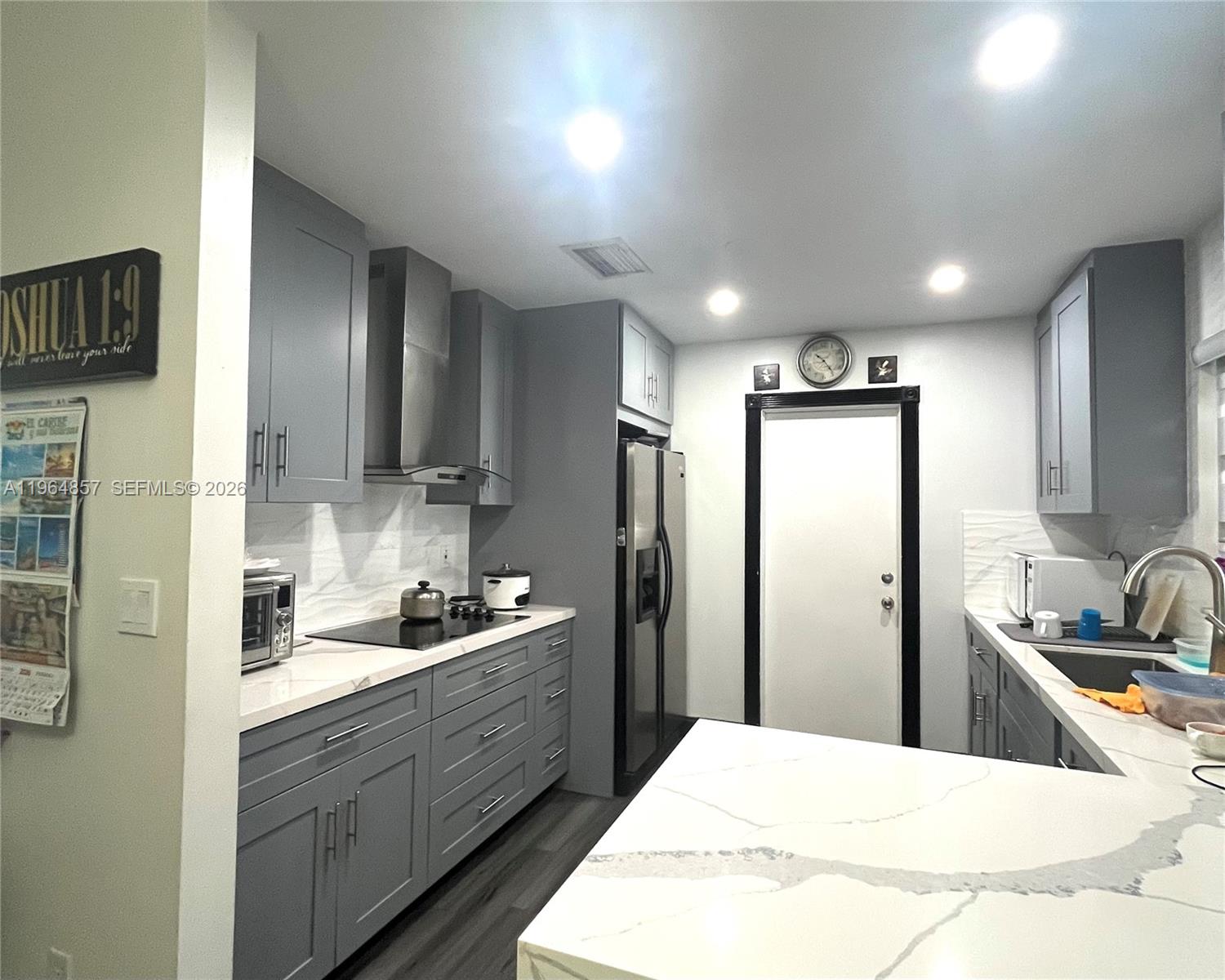 12271 Southwest 187th Street Miami, FL 33177 - Photo 9 of 27 a kitchen with stainless steel appliances kitchen island granite countertop a refrigerator and a sink