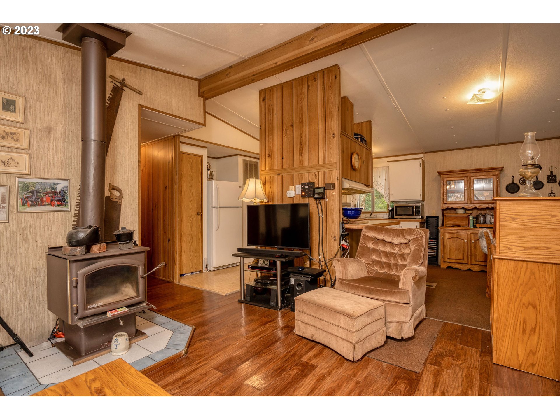 26720 Northwest Williams Canyon Road Gaston, OR 97119 - Photo 28 of 33 a living room with furniture a flat screen tv and a refrigerator