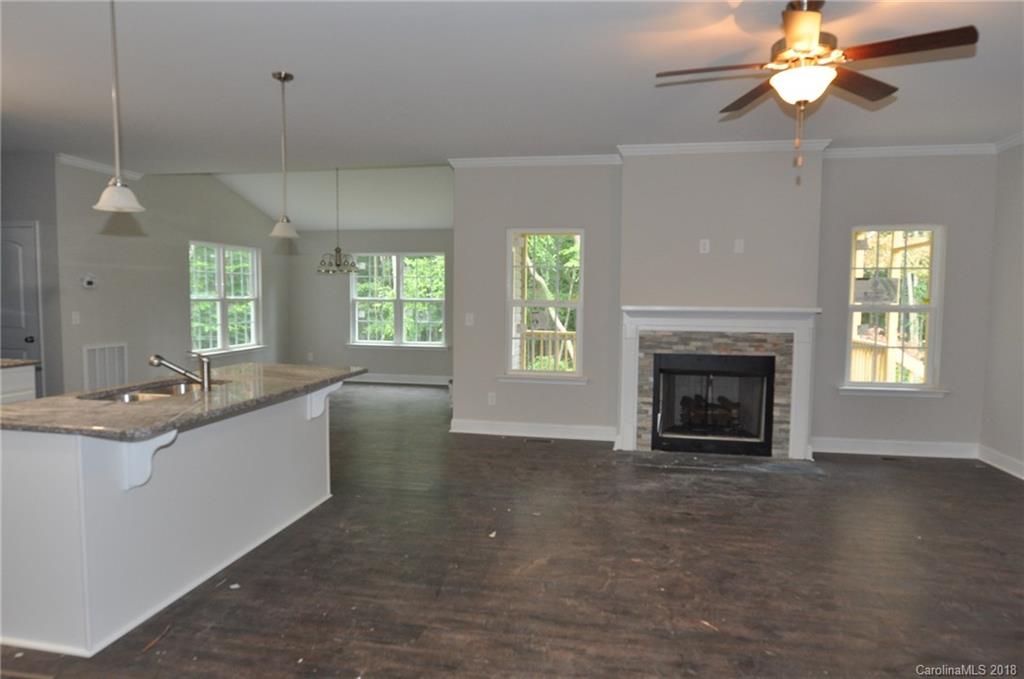 4081 Ruston Creek Road, Unit 83 Catawba, SC 29704 - Photo 4 of 27 a large kitchen with a fireplace and a chandelier fan