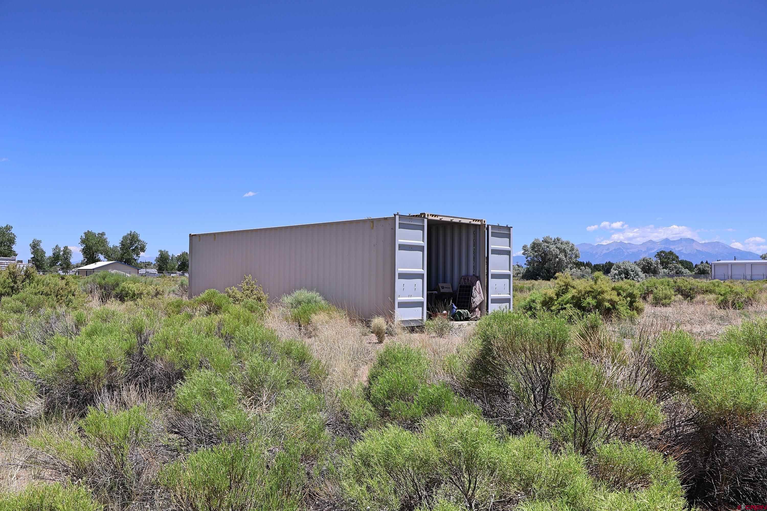 2416 Commerce Circle Alamosa, CO 81101 - Photo 2 of 6 a backyard of a house with lots of green space and a house in the background