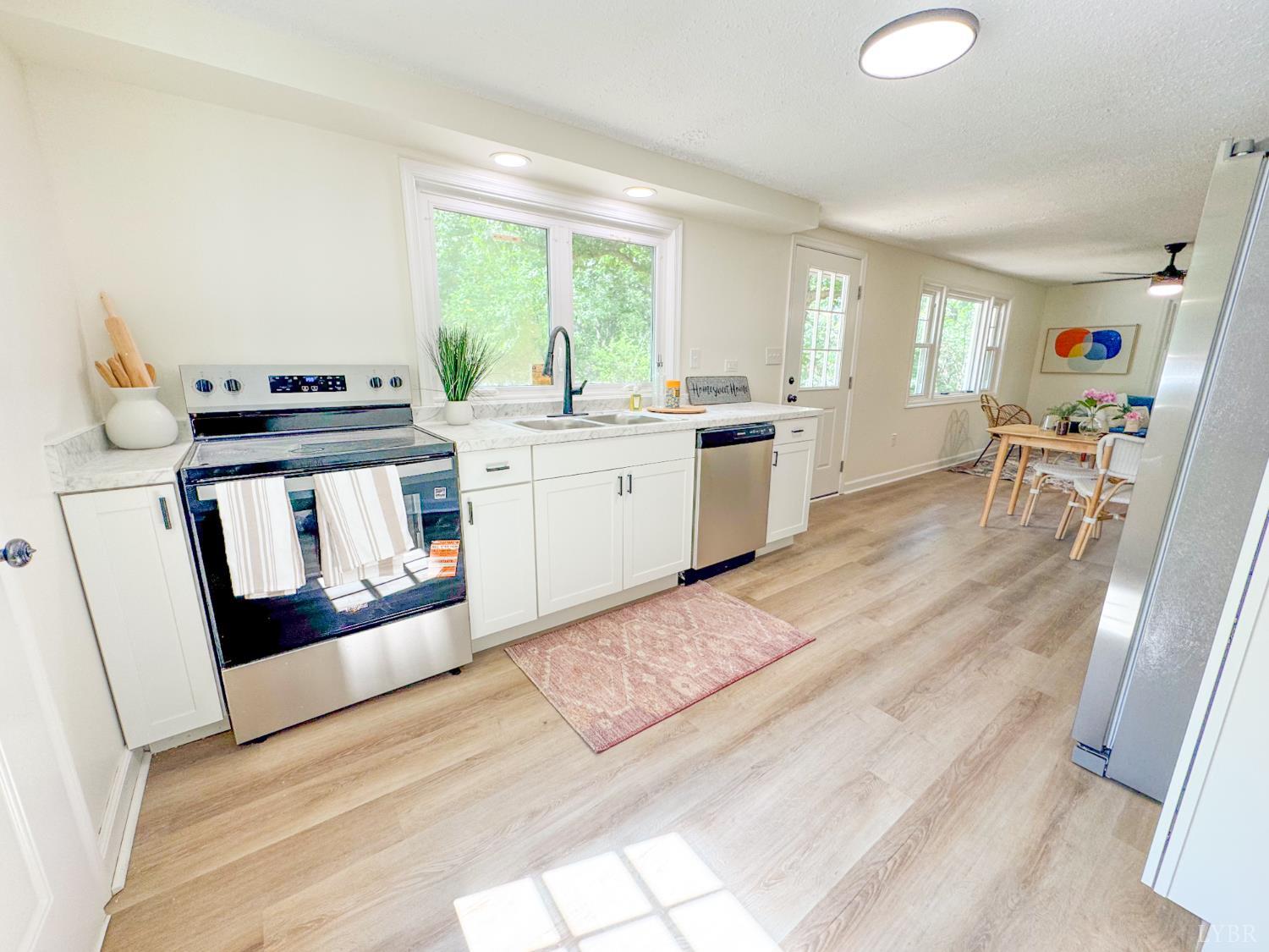 684 East Ferry Road Gladys, VA 24554 - Photo 7 of 20 a kitchen with stainless steel appliances granite countertop a stove a sink dishwasher and a refrigerator with wooden floor