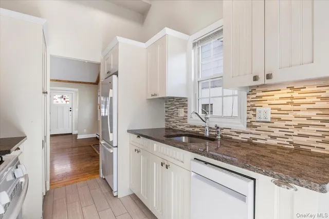 a kitchen with granite countertop a sink and a stove