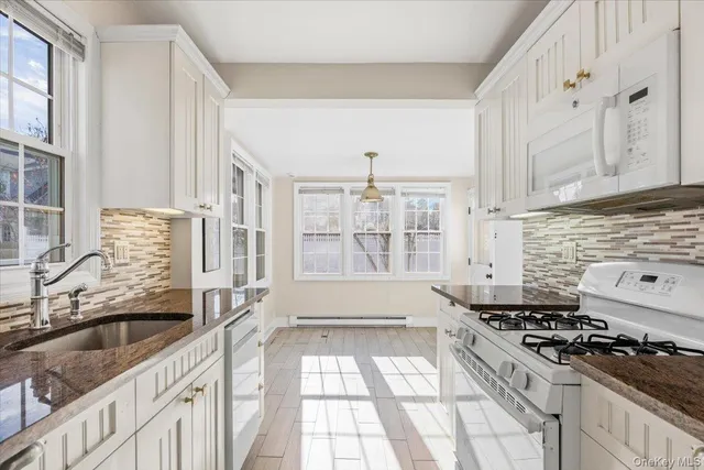 a kitchen with a sink stove top oven and cabinets
