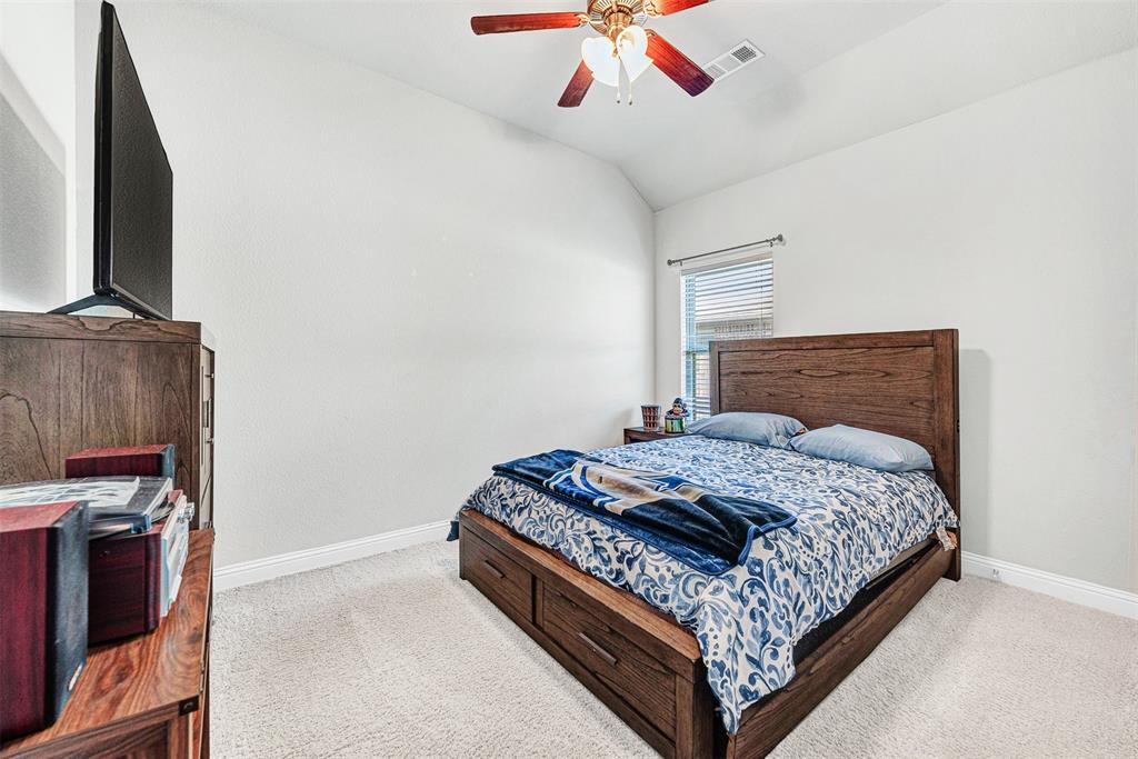 1313 Torrington Lane Forney, TX 75126 - Photo 17 of 21 a bed sitting in a bedroom next to a tv