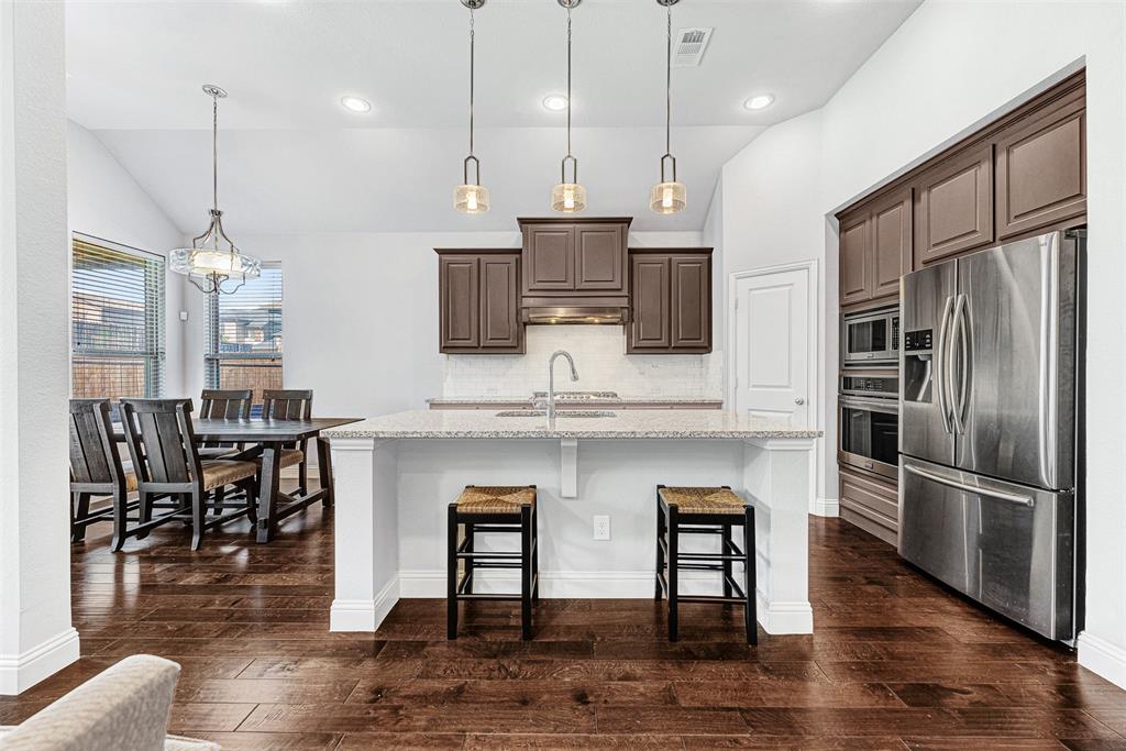 1313 Torrington Lane Forney, TX 75126 - Photo 4 of 21 a kitchen with stainless steel appliances granite countertop a kitchen island hardwood floor and a sink