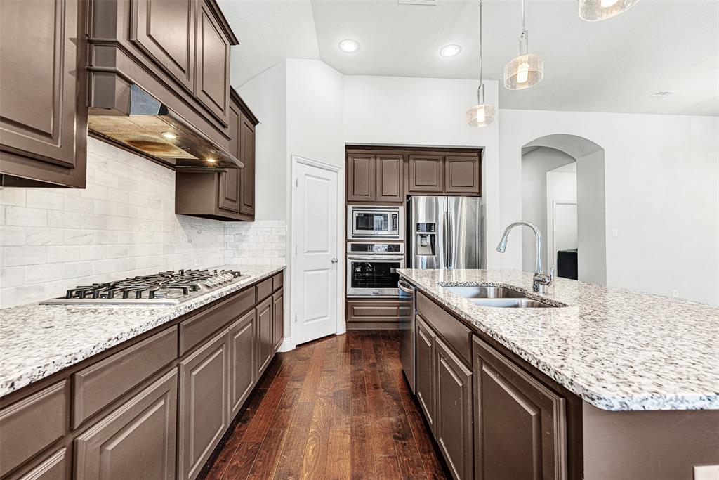 1313 Torrington Lane Forney, TX 75126 - Photo 6 of 21 a kitchen with stainless steel appliances granite countertop a sink stove and cabinets