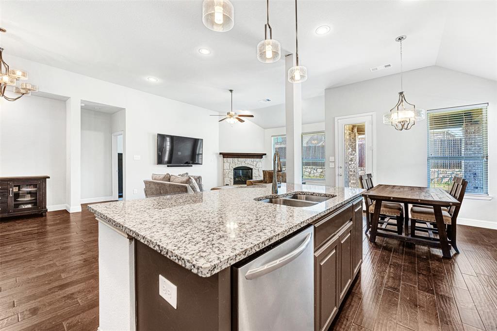 1313 Torrington Lane Forney, TX 75126 - Photo 7 of 21 a kitchen with granite countertop a table chairs sink and wooden floor