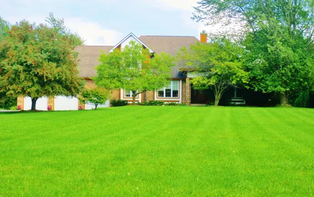 a front view of a house with a garden and yard