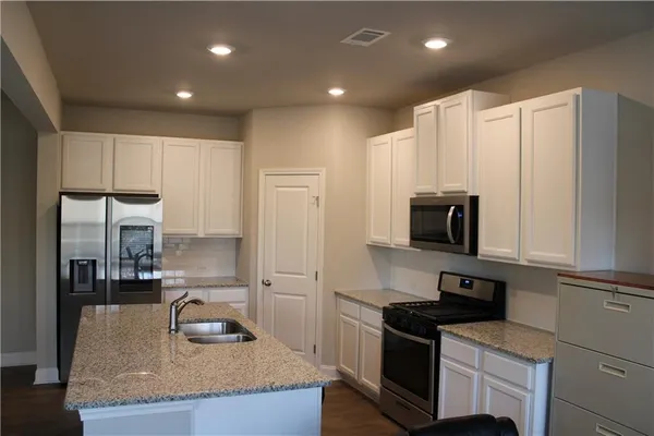 a kitchen with a refrigerator and cabinets