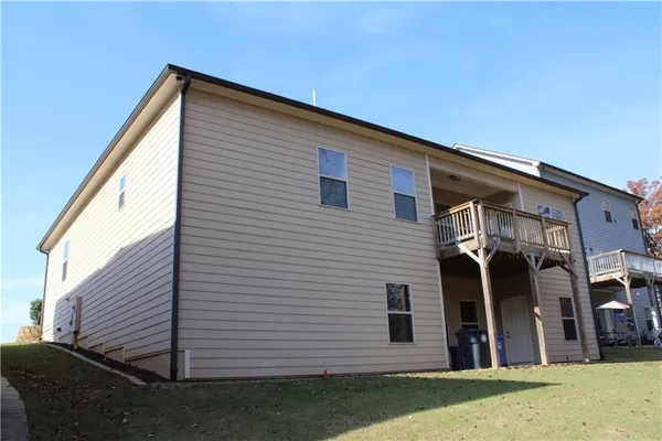 a view of house with deck and furniture