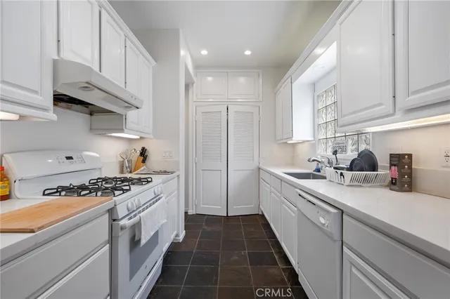 a kitchen with white cabinets and appliances