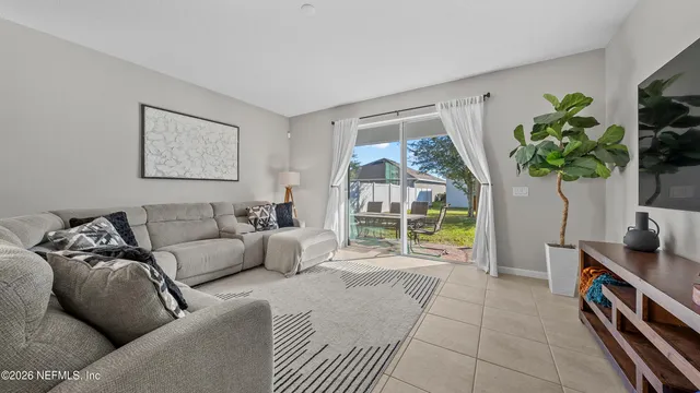 a living room with furniture and a view of kitchen