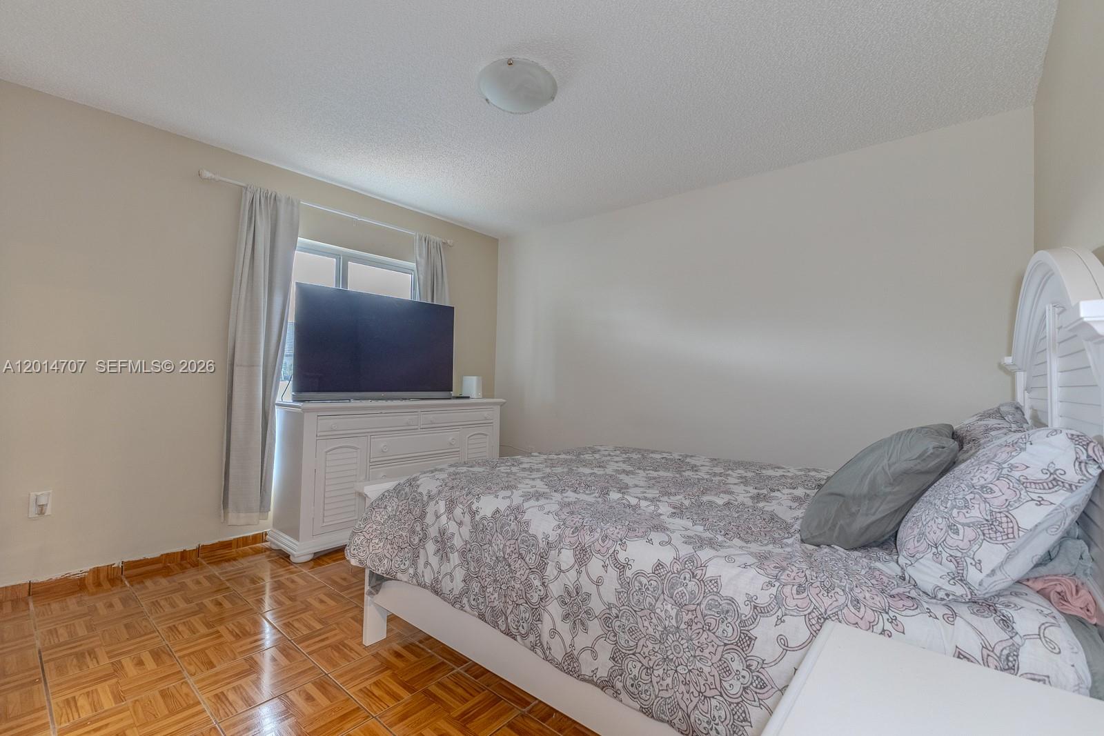 14452 Southwest 115th Street Miami, FL 33186 - Photo 12 of 17 a bedroom with a bed and a mirror