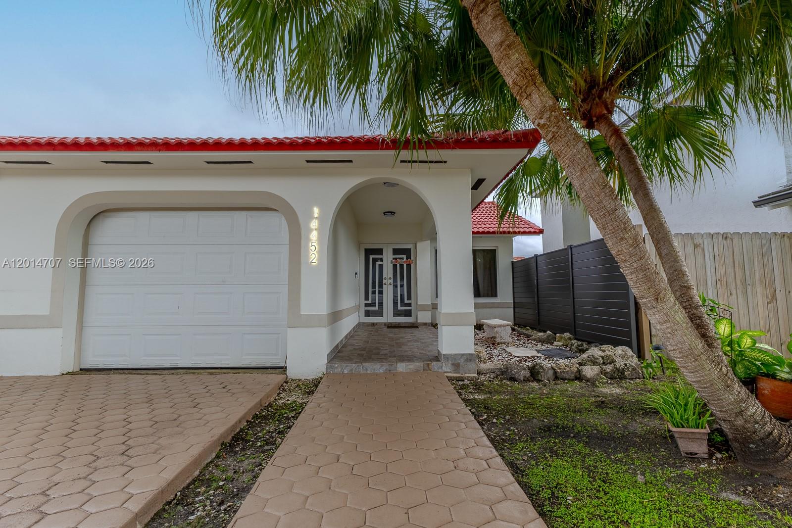 14452 Southwest 115th Street Miami, FL 33186 - Photo 2 of 17 a front view of a house with garden