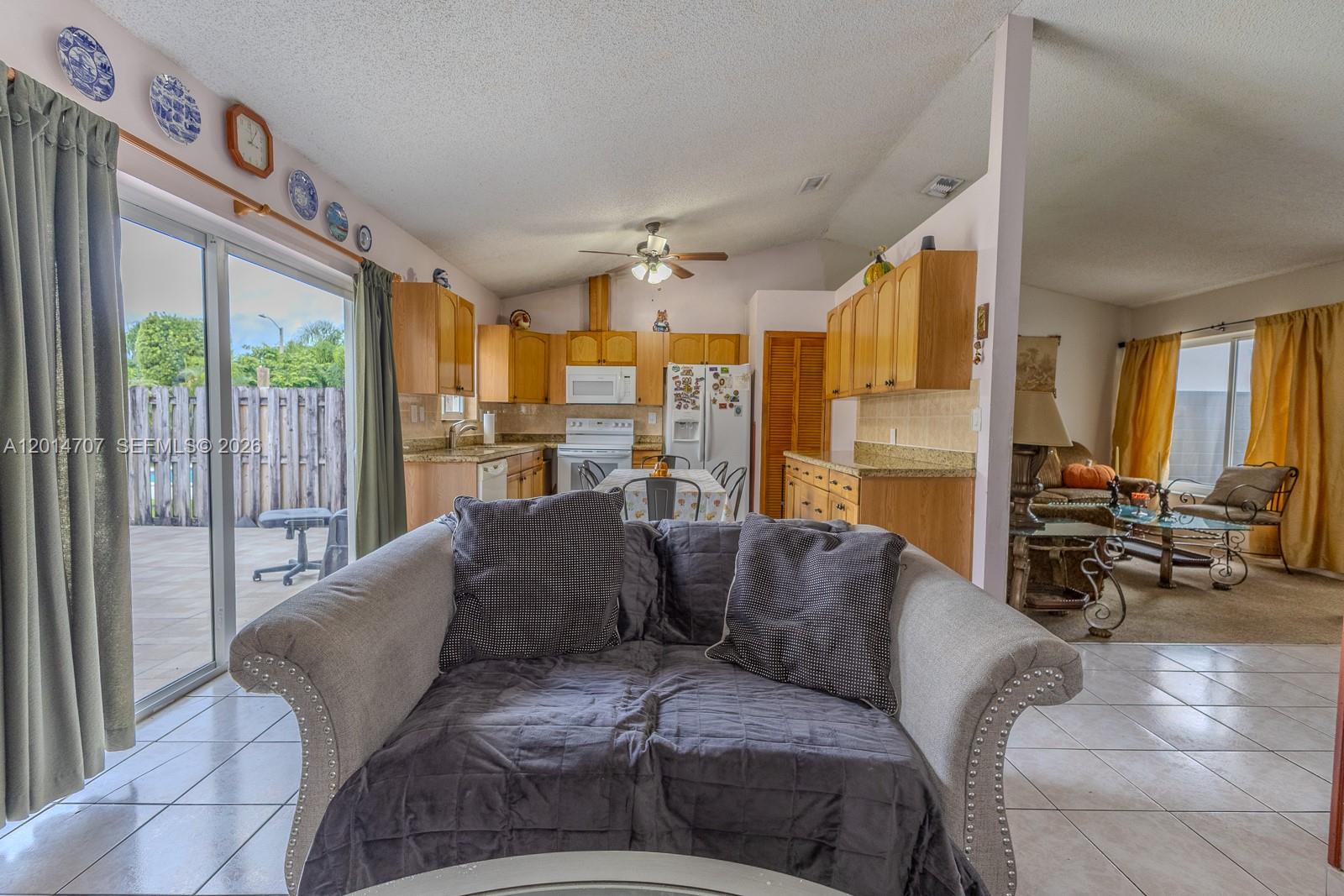 14452 Southwest 115th Street Miami, FL 33186 - Photo 5 of 17 a large living room with a large window and a glass door