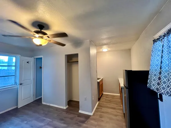 wooden floor in an empty room with a chandelier fan