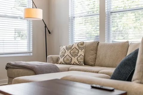 a kitchen with kitchen island granite countertop a dining table chairs and white cabinets
