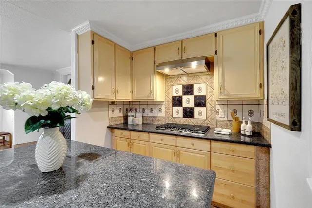 a kitchen with stainless steel appliances granite countertop a sink a stove and a wooden cabinets