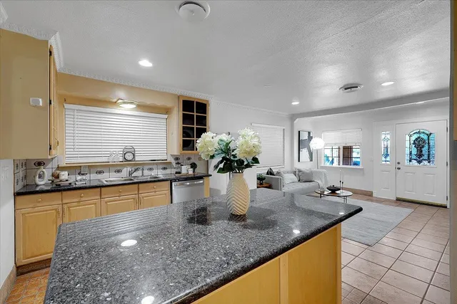 a kitchen with a sink a counter top space and living room