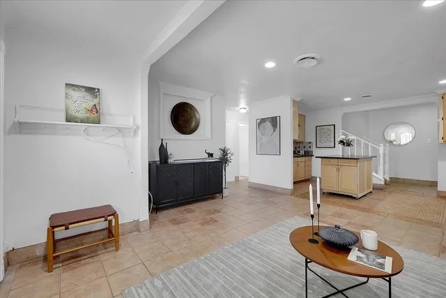 a living room with furniture a rug and a wall painting