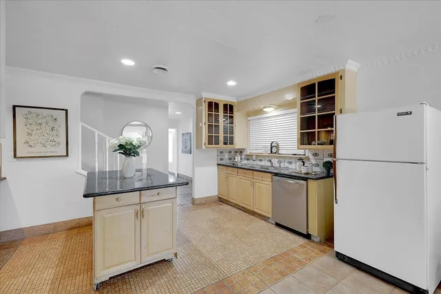 a kitchen with granite countertop a refrigerator and cabinets
