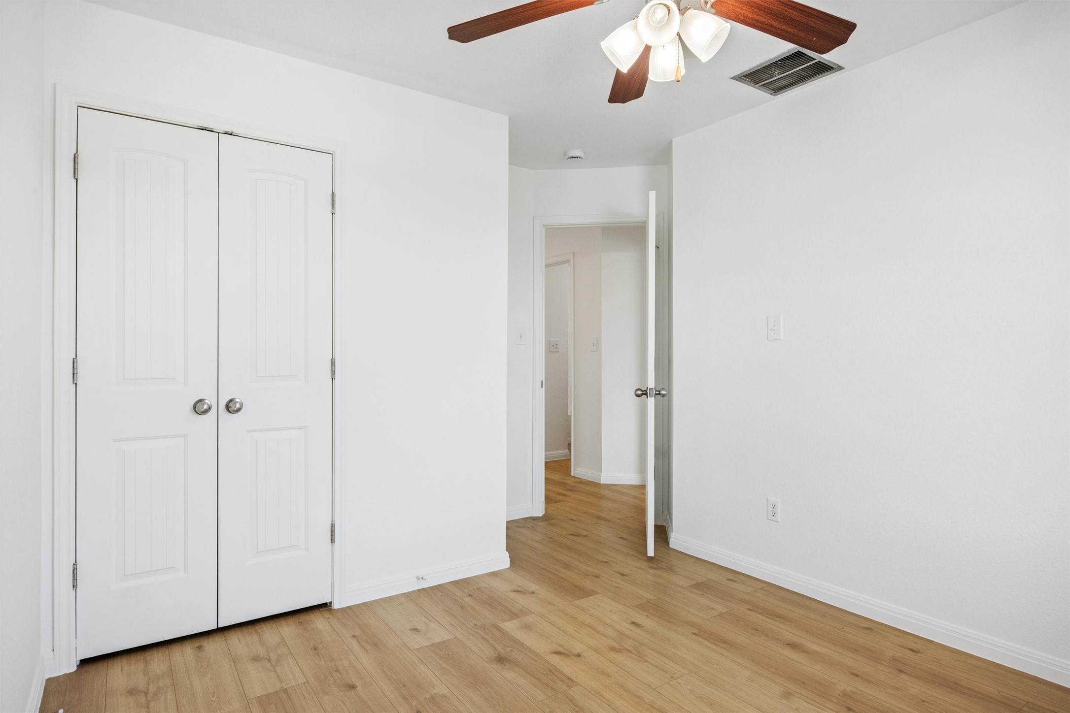 4516 Kind Way, Unit 253 Austin, TX 78725 - Photo 17 of 31 an empty room with wooden floor fan and windows