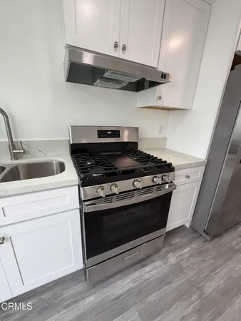 a stove top oven sitting inside of a kitchen