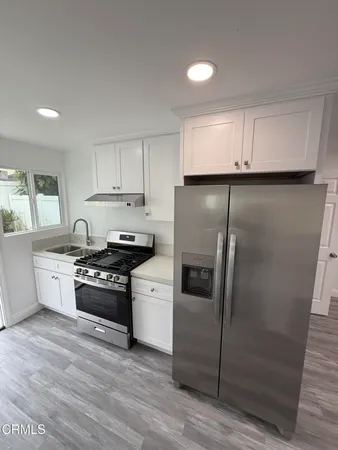 a kitchen with granite countertop a refrigerator stove and sink