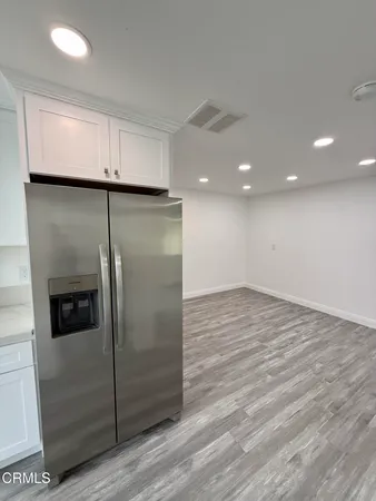 a view of a refrigerator in kitchen and wooden floor