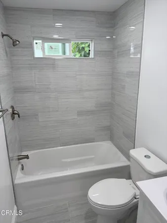 a white toilet sitting next to a bath tub and shower