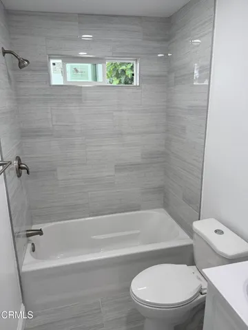 a white toilet sitting next to a bath tub and shower