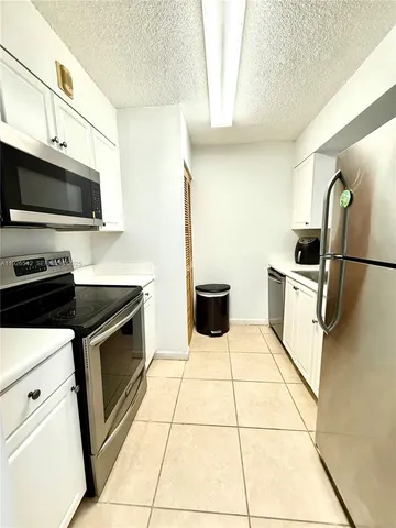 a kitchen with stainless steel appliances a refrigerator sink and microwave