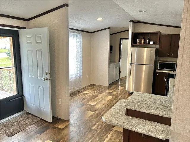 a kitchen with stainless steel appliances granite countertop a sink stove refrigerator and cabinets