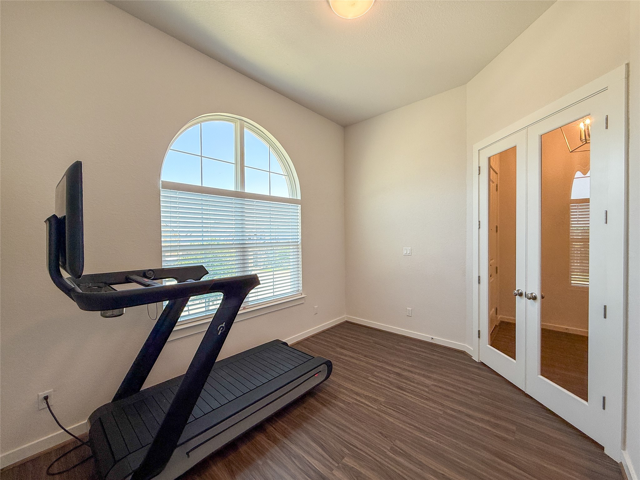 249 Heartleaf Road San Marcos, TX 78666 - Photo 7 of 38 French doors open to an inviting space with a large arched window, offering abundant natural light.