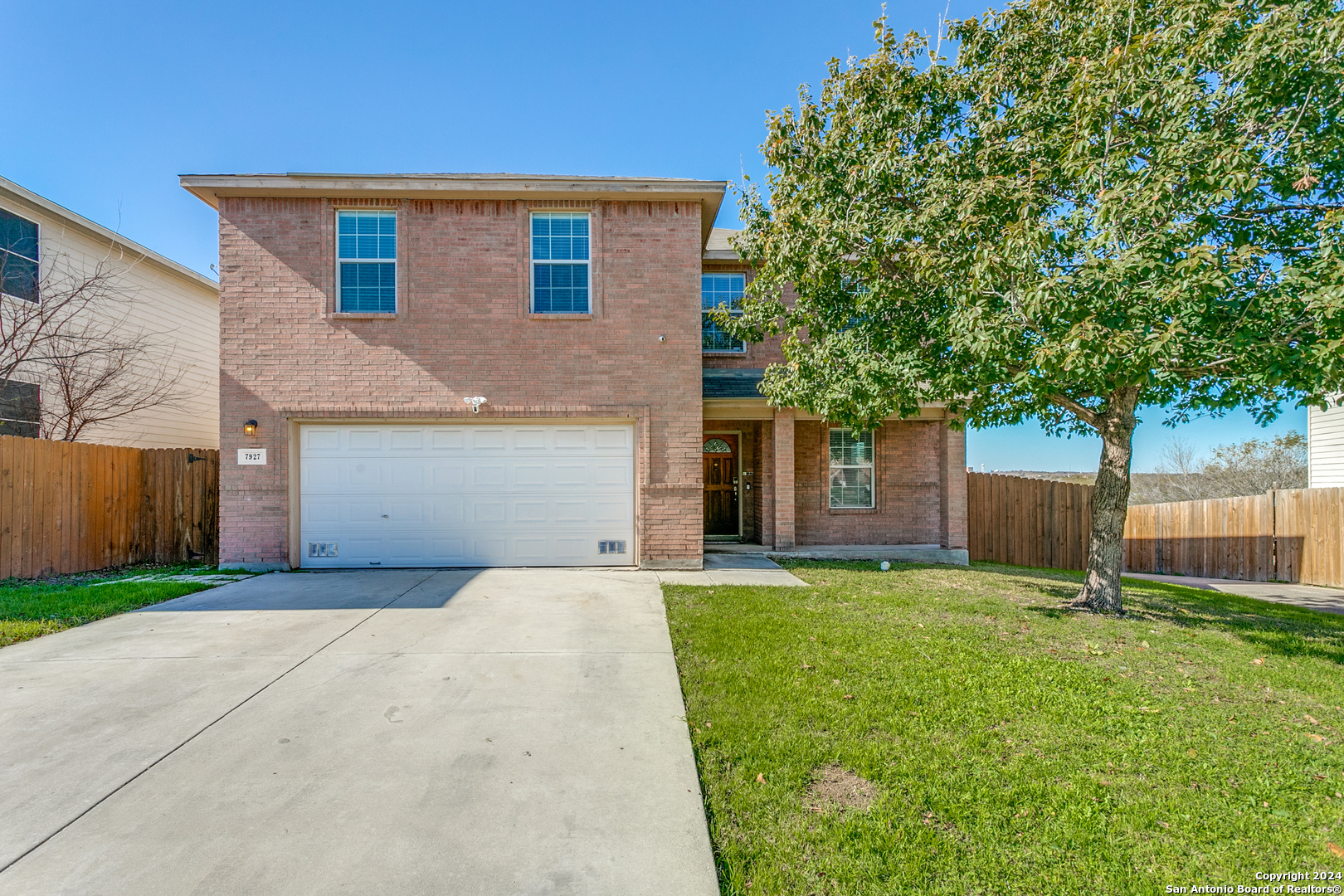 a front view of a house with a yard and trees