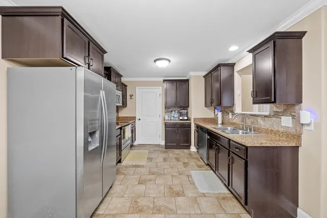 a kitchen with stainless steel appliances granite countertop a refrigerator and a sink
